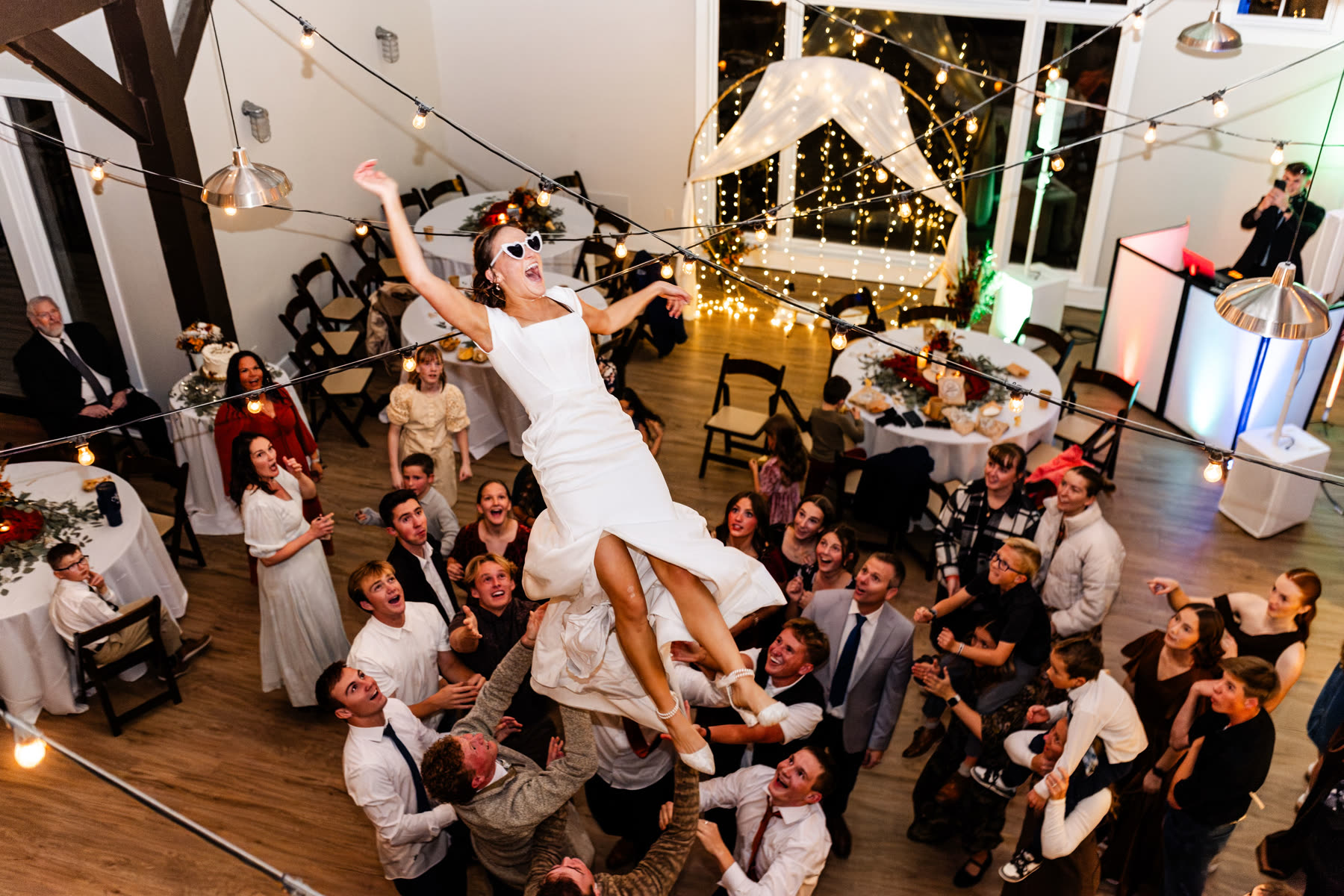 Bride lifted by guests on the dance floor