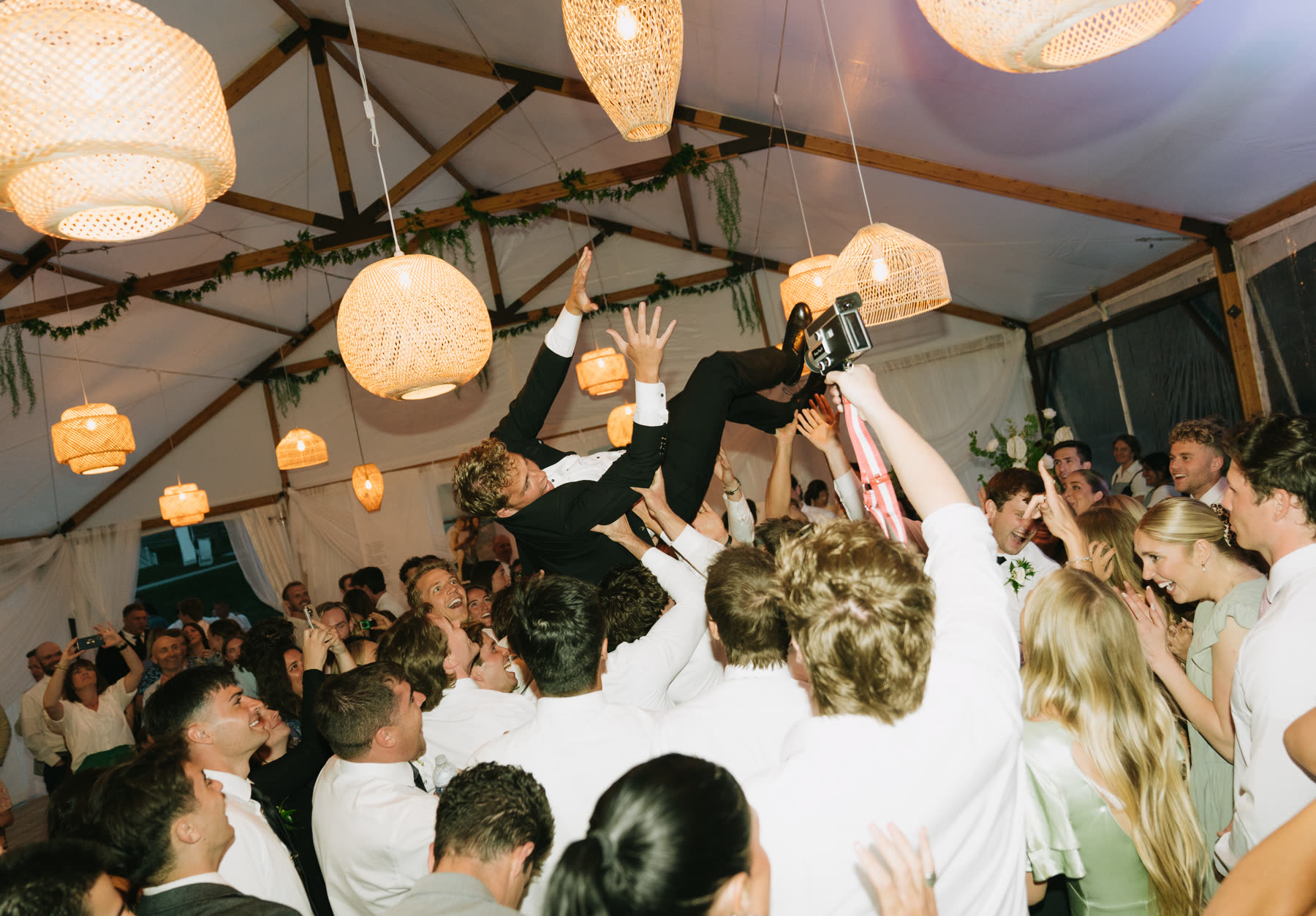 Groom crowd surfing at the reception